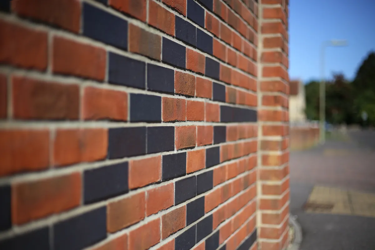 Fresh mortar being struck into the joints of a brick wall