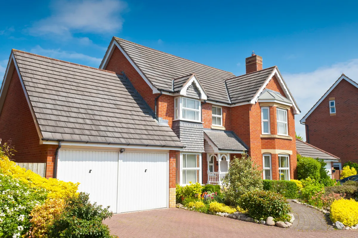 A red brick house in West London with a finished concrete tiled roof